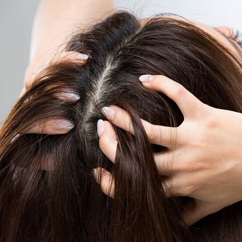 Woman applying moehair hair guard tonic on her scalp 